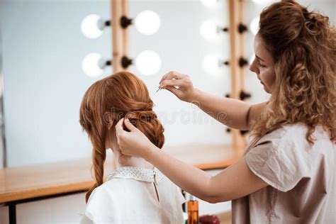 female hairdresser making hairstyle to redhead girl in beauty salon stock image image of