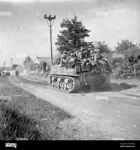 The British Army In Normandy 1944 Sherman Tanks Carrying Infantry Move