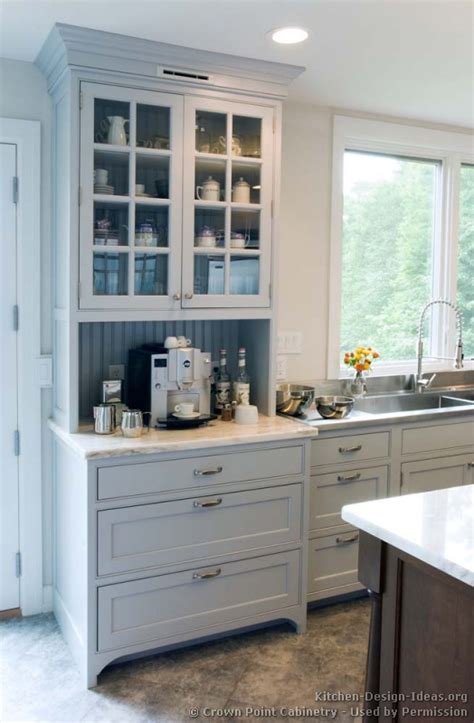 I like how she repeated the light wood tones in the pendants and a wood detail on the. Transitional Kitchen Design with Pale Blue Shaker Style Cabinets