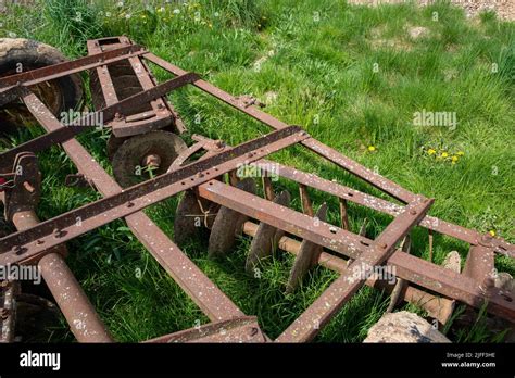 Antique Disc Harrow Agricultural Farm Implement In Green Meadow Stock
