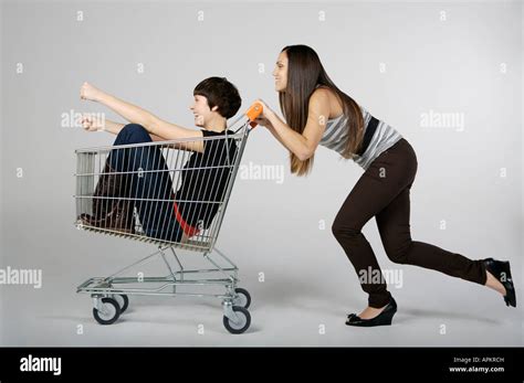 Two Women Playing With A Grocery Cart Stock Photo Alamy