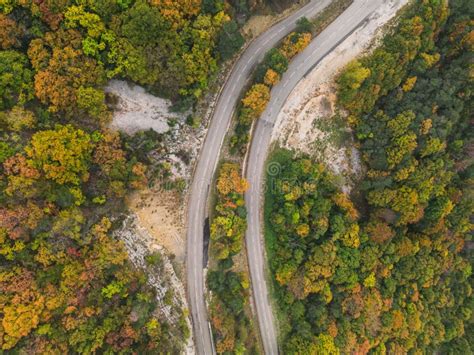 Aerial View Of A Winding Road From A High Mountain Pass Through A Dense
