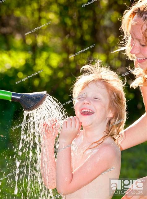 Portrait Of Cute Little Girl Taking A Shower Outdoors Stock Photo