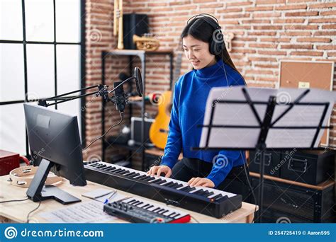 Chinese Woman Musician Playing Piano Keyboard At Music Studio Stock