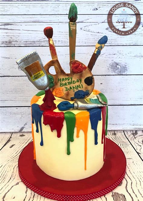 A Birthday Cake Decorated With Paint And Brushes