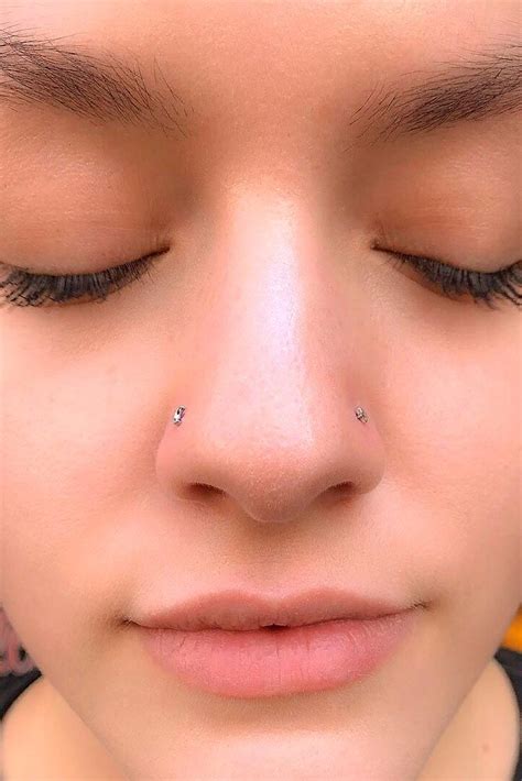 a close up of a person with their eyes closed and nose piercing in the middle