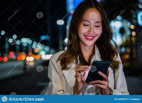 Business Woman Using Mobile Phone Walking Through Night City Street