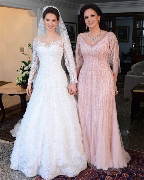 Two Women In Wedding Dresses Standing Next To Each Other On A Carpeted