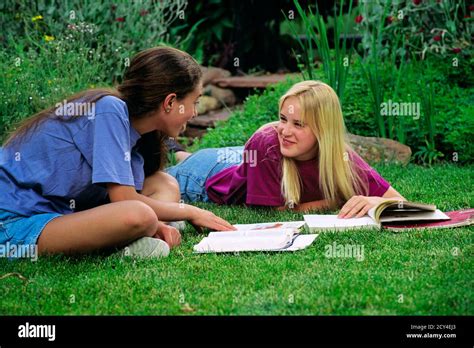 Dos Chicas Adolescentes Sonriendo Sentadas En Un Patio De C Sped Libros Escolares Abiertos