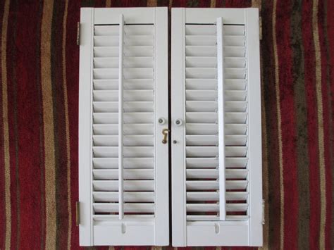 Two Hinged White Wooden Louvered Interior Window Shutters That