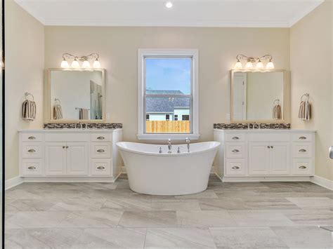 Master Bathroom With Separate Vanities And A Freestanding Bath Tub