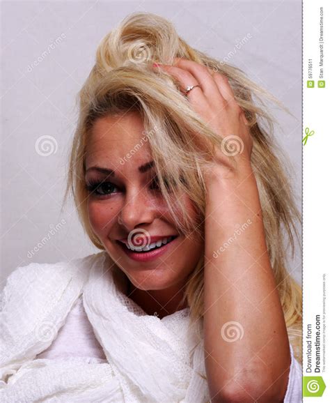 A Smiling Blond Haired Woman Is Looking Into The Camera Stock Image