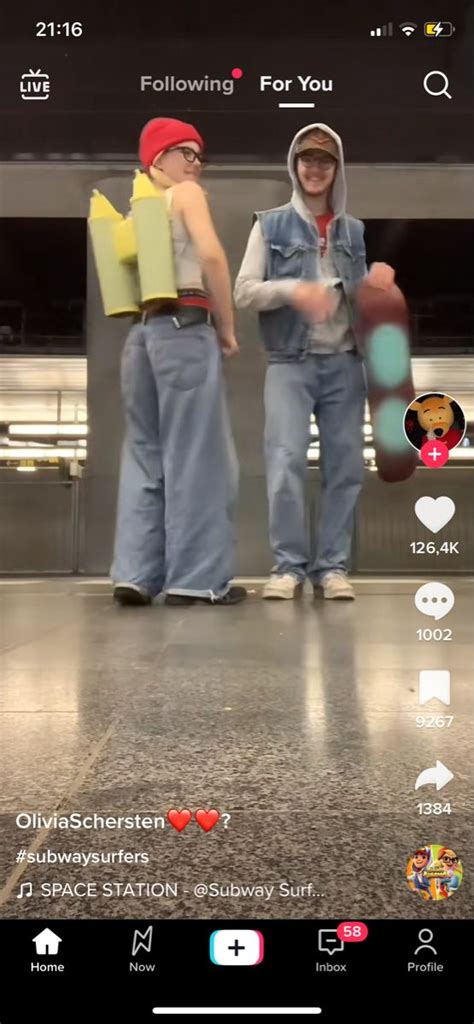two people are standing in an airport with their backs turned to the camera and one person is