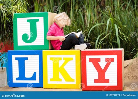 Child Reading Book In School Yard Kid Learning Abc Letters Stock Image