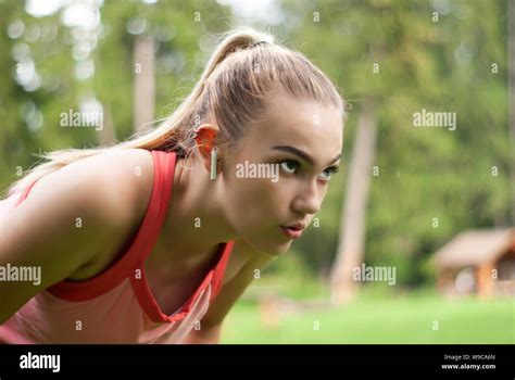 Young Woman Is Out Of Breath And Makes A Breather Bent Over While Doing Sports Outdoors Stock