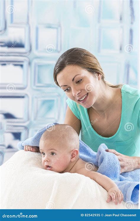 Mother Is Drying Her Baby Boy After Bathing With Tenderness Stock Image