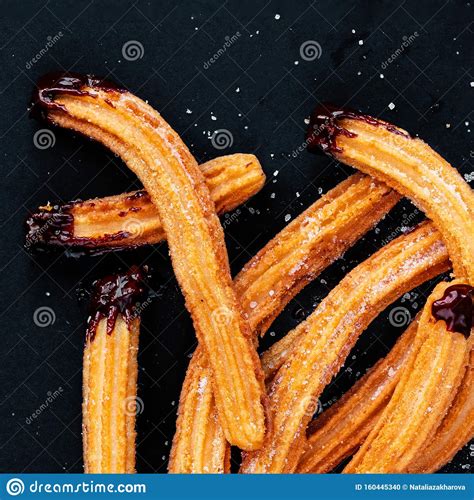 Traditional Churros With Sugar And Chocolate Sauce On Black Background