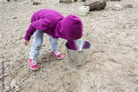 Little Girl Bending Down Playing With Rocks Stock Photo Adobe Stock
