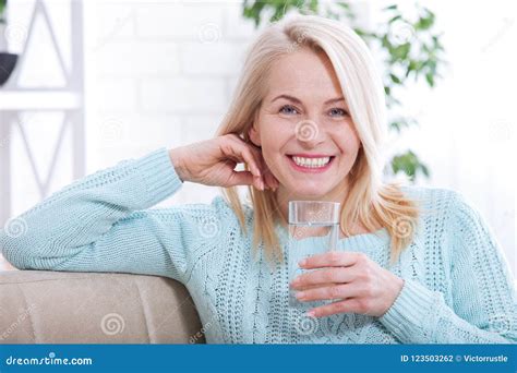 Όμορφο μέσο ηλικίας πόσιμο νερό γυναικών το πρωί Στοκ Εικόνες εικόνα από Lifestyle Bathos