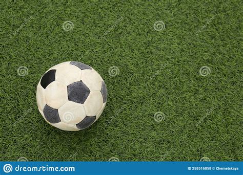 Dirty Soccer Ball On Green Football Field Top View Space For Text
