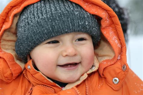 Premium Photo Smiling Baby With Snow In Winter