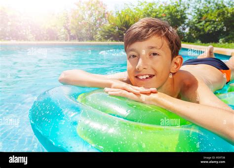 Close Up Portrait Of Teenage Boy Sunbathing On Inflatable Mattress In