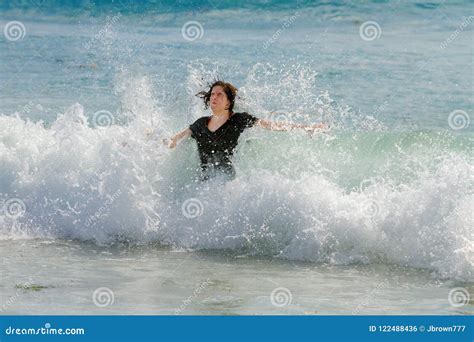 Teen Girl In The Ocean Facing The Shore With Arms Outstretched B Stock
