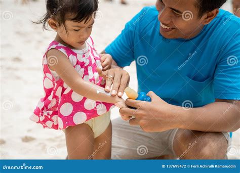 A Daughter Feels Strange When Father Rubbing A Sunblock To His Arm