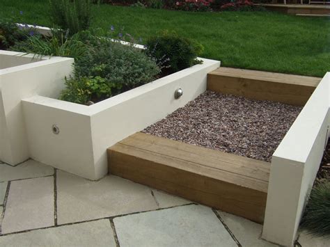 A Paved Terrace And Steps Made Using Sleepers Lead Up To Lawns In This