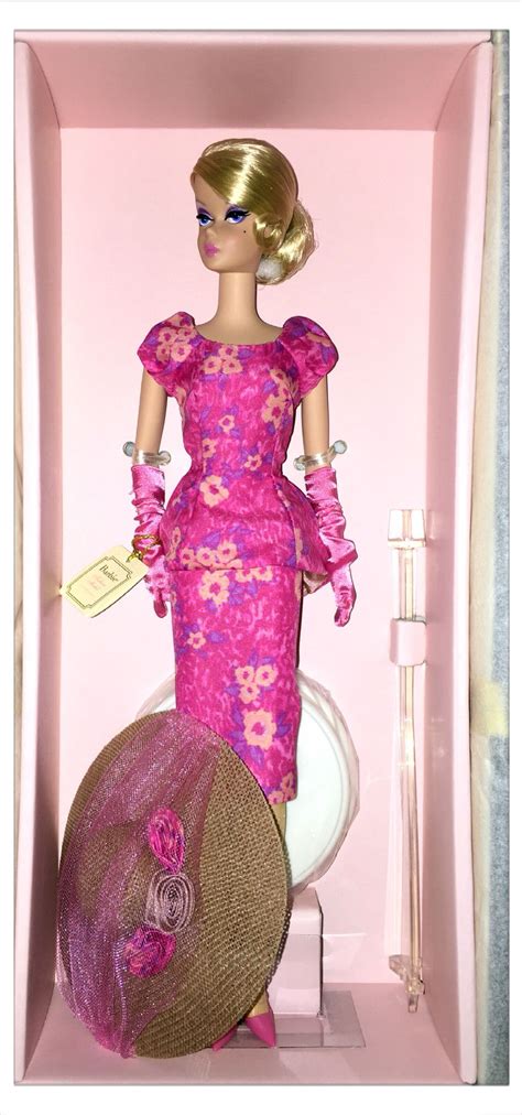 A Barbie Doll In A Pink Dress And Hat