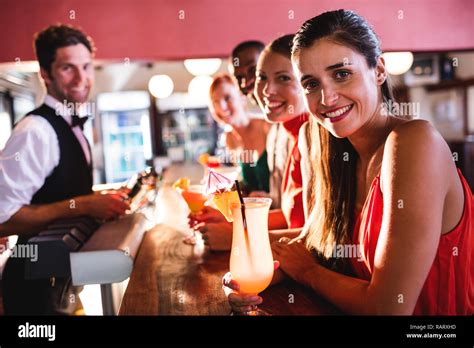 Friends Enjoying Drinks On Bar Counter In Nightclub Stock Photo Alamy