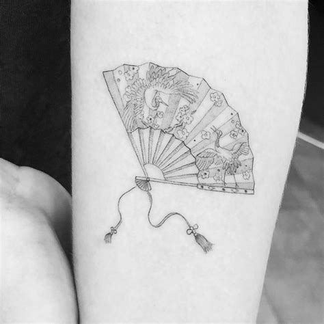 a black and white photo of a fan tattoo