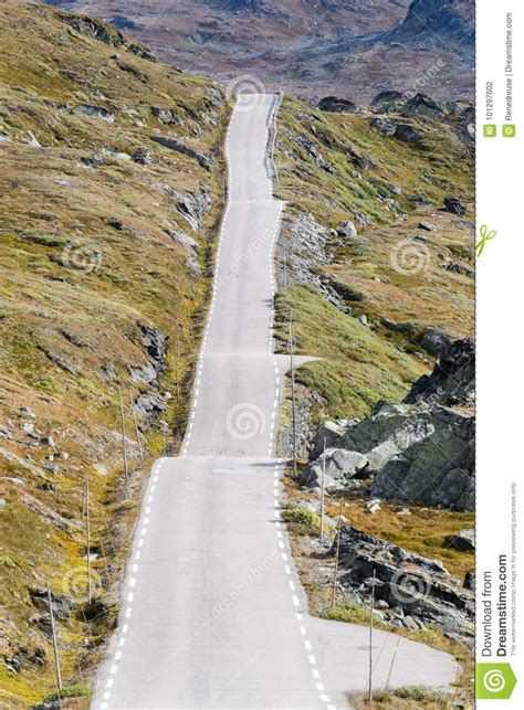 Straight And Bumpy Mountain Road Across Rocky Landscape Stock Photo