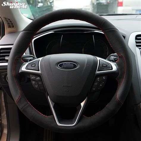 The Interior Of A Car With Red Stitching And Steering Wheel Cover On It