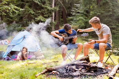 Teenagers Camping In Forest Summer Adventure Stock Photo By Halfpoint