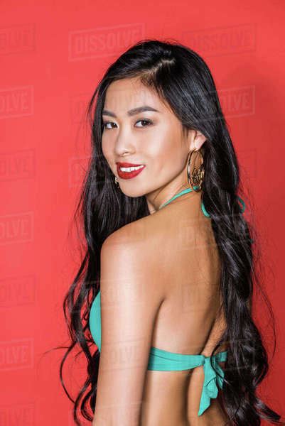 Portrait Of A Smiling Asian Woman In Turquoise Swimsuit Standing Half Turned And Looking At