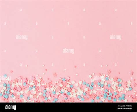 Festive Border Frame Of Colorful Pastel Sprinkles On Pink Background