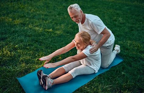 Senior Couple Is Doing Sport Outdoors Stretching In Park During