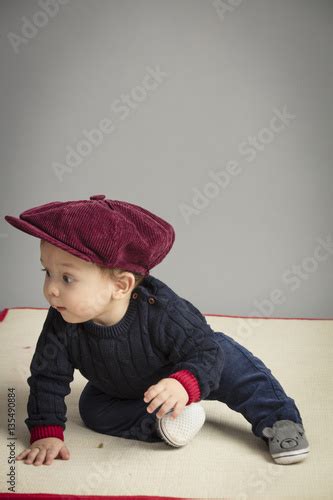 Caucasian Small Boy Sitting On Carpet Inside Studio Stock Photo And