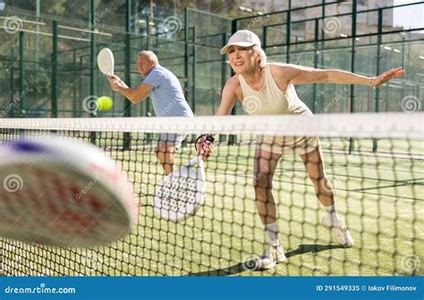 Old Man And Woman Playing Padel Tennis In Open Air Tennis Court Stock