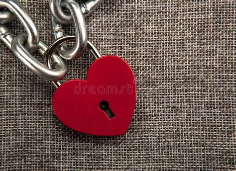 Red Locked Heart Shaped Padlock With Steel Chain On Gray Linen Textile