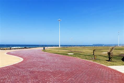 Paved Promenade And Sea Against Blue Cloudy Sky Landscape Stock Image