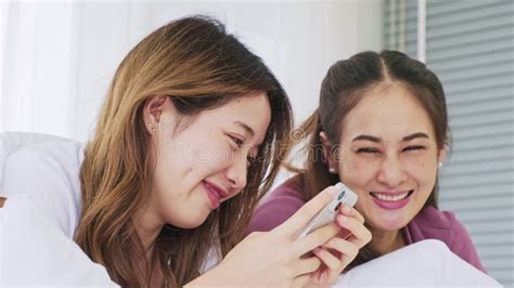 Happy Asian Women Couple Laying In Bed Using Laptop For Online Shopping