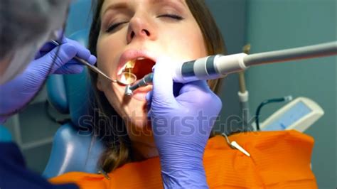 Girl At The Dentist Watches As Her Teeth Are Drilled By A Female