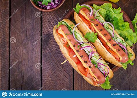 Hot Dog With Sausage Cucumber Tomato And Lettuce On Dark Wooden
