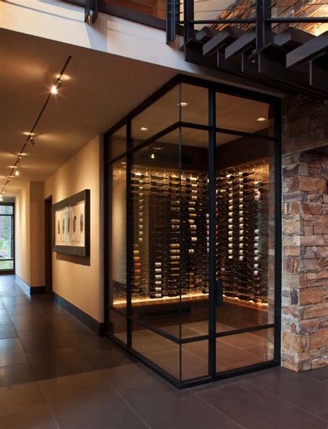 The Inside Of A Wine Cellar With Glass Walls And Stairs Leading Up To