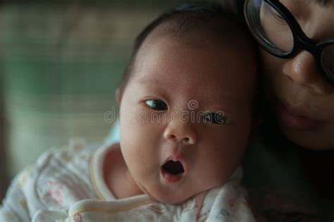 Cute Baby With Wide Eyes Lying In Mother`s Arms Stock Photo Image Of