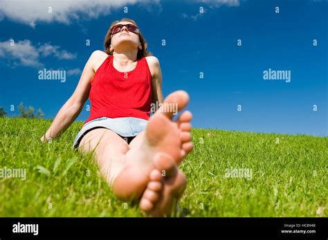 Young Woman Sitting Barefoot In Summer Meadow Relaxing Stock Photo Alamy