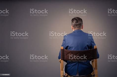 Rear View Of A Man Sitting Against The Wall Stock Photo Download