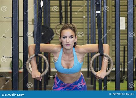 Fit Woman Exercising With Gymnastics Rings At A Gym A Health Club Or Fitness Studio Stock Photo